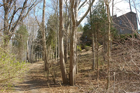 The trail passes near this house before going down a hill.