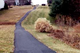 The trail crosses a private driveway at the top of the hill and continues to follow the pipeline.