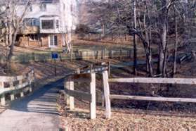 The service road joins an asphalt path and turns right at the end of the park.  Follow the path between the wooden fences.