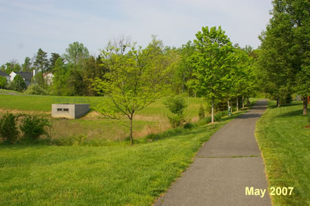 The trail enters a large grassy area.  Stay straight on this trail not turning at the next asphalt trail on the right.