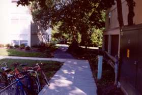 Take the first concrete sidewalk to the right at the end of the building.  It leads to an asphalt trail.