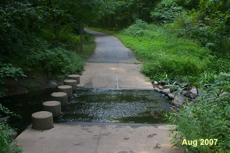 The trail crosses a small stream on columns.