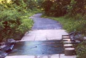 The trail crosses a stream on columns.