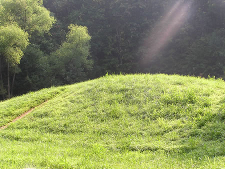 The trail crosses a dam forming a water retention basin.