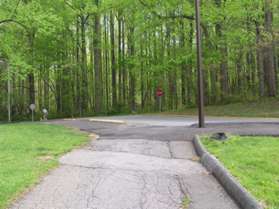 The path comes to an access road to the dog park.