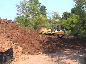 This bulldozer is grading the north side near the bridge.